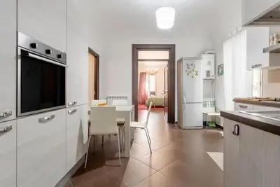 a kitchen with a table and a kitchen with white appliances at Casa Lulú in Palermo
