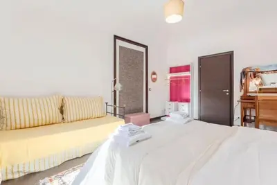 a bedroom with a large white bed and a couch at Casa Lulú in Palermo