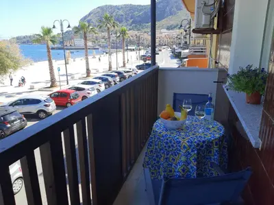a table on a balcony with a view of a street at GiRosa House in Bagheria