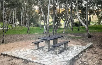 a stone bench sitting in a park with trees at Stunning Apartment In Balestrate in Balestrate