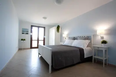 a bedroom with a large bed with white pillows at Casa Turchese Unmarediblu in San Vito lo Capo