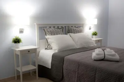 a bedroom with a bed with two night stands and two lamps at Casa Turchese Unmarediblu in San Vito lo Capo