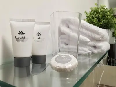a glass table with two bottles of soap and towels at Casa Turchese Unmarediblu in San Vito lo Capo