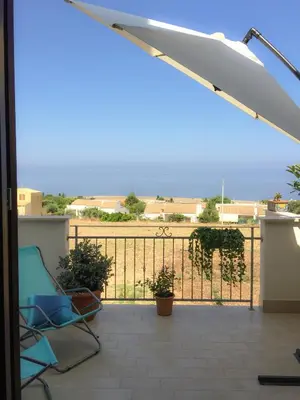 a patio with a blue chair and a fence at Casa Turchese Unmarediblu in San Vito lo Capo