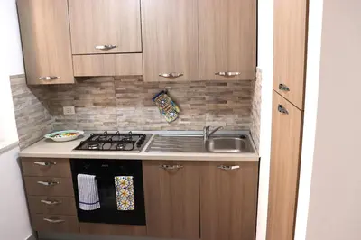 a small kitchen with a stove and a sink at Central apartment with charm for 1 or 2 people - Casa Vacanze Luna in Lascari