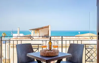 a table with two glasses of wine on a balcony at Beautiful Apartment In Balestrate in Balestrate