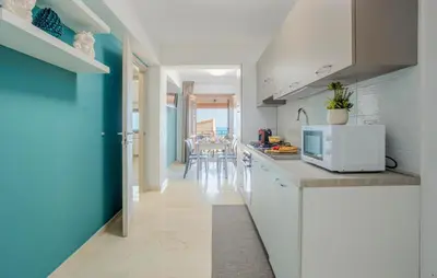 a kitchen with white cabinets and a blue wall at Beautiful Apartment In Balestrate in Balestrate