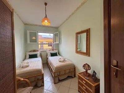 a bedroom with two beds and a mirror at Aspra Mare House in Ficarazzi