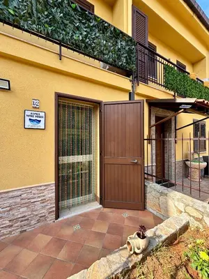 a house with a brown door and a balcony at Aspra Mare House in Ficarazzi