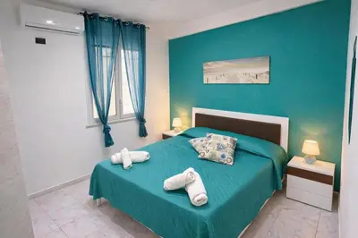 a blue bedroom with a bed with towels on it at Rossella Apartment 5 posti vicino spiaggia San Vito Lo Capo in San Vito lo Capo