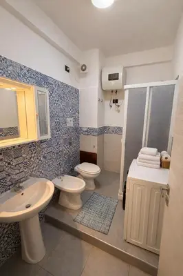 a kitchen with wooden cabinets and a stove top oven at Rossella Apartment 5 posti vicino spiaggia San Vito Lo Capo in San Vito lo Capo