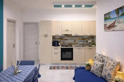 a living room with a blue couch in a kitchen at Rossella Apartment 5 posti vicino spiaggia San Vito Lo Capo in San Vito lo Capo