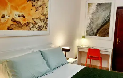 a bedroom with a bed and a red chair at Casa d'artista Max Serradifalco in Palermo