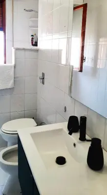a white bathroom with a toilet and a sink at Casa d'artista Max Serradifalco in Palermo
