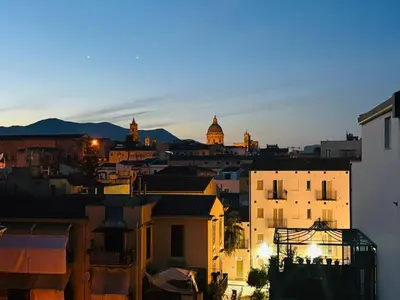 a view of a city at sunset with buildings at Casa Mortillaro - The Heart of Palermo, Ballaro Market in Palermo