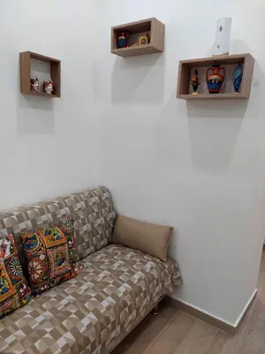a couch sitting next to a wall with shelves at Sweet dreams AF in Palermo