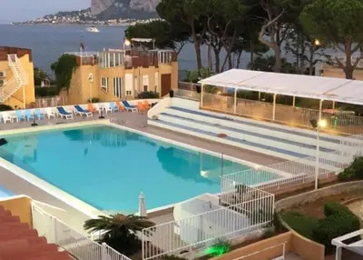 arial view of a resort with a swimming pool and the ocean at Mondello 50 Ashur in Palermo
