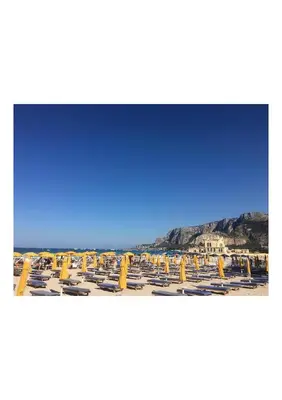 a group of yellow umbrellas on a beach at Mondello 50 Ashur in Palermo