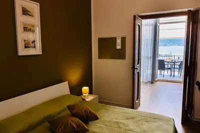 a bedroom with a bed and a door to a balcony at beach front bliss mondello in Palermo