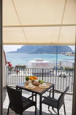 a table and chairs with a view of the ocean at beach front bliss mondello in Palermo