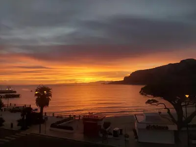 a sunset over a body of water with the ocean at beach front bliss mondello in Palermo