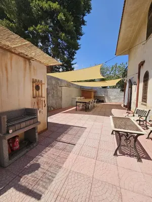 a patio with a grill and tables and benches at IL GEKO tra Palermo e Cefalu' nel mare di Sicilia in Trabia