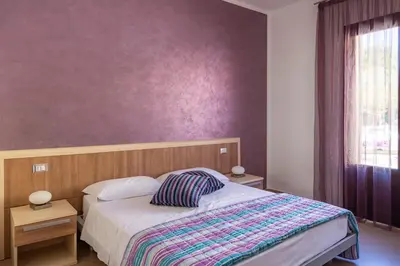 a bedroom with a bed and a purple wall at Bed&Breakfast Acasamia in Castelluzzo