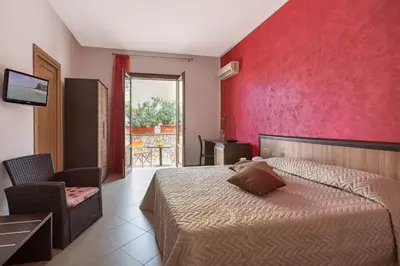 a bedroom with a bed and a red wall at Bed&Breakfast Acasamia in Castelluzzo