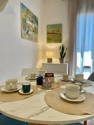 a table with plates and cups and saucers on it at CasaPA-Appartamento a due passi dal Teatro Massimo in Palermo