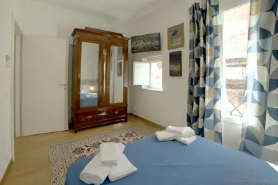 a bedroom with a blue bed with towels on it at Adenzia Suite in Palermo