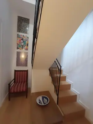 a staircase with a red chair and a plate on the floor at Adenzia Suite in Palermo