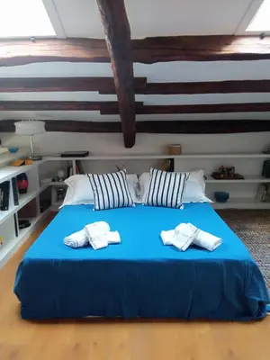 a bedroom with a blue bed with two towels on it at Adenzia Suite in Palermo