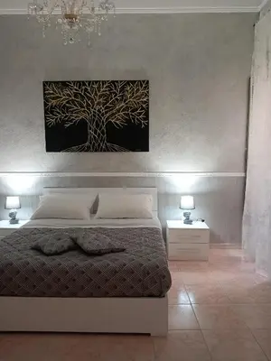 a bedroom with a tree painting on the wall at Casa Vacanza Marion in Palermo