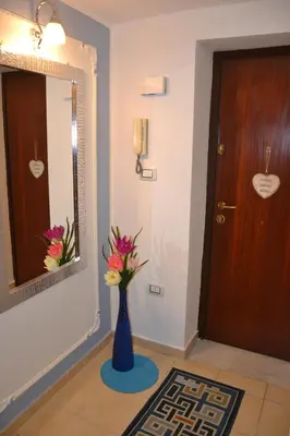 a hallway with a blue vase with flowers in it at Quattro Canti Valù in Palermo