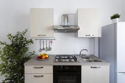 a kitchen with a sink and a bowl of fruit at Dimora Alla Magione in Palermo