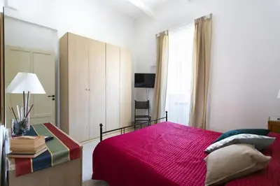a bedroom with a bed with a red comforter at Dimora Alla Magione in Palermo