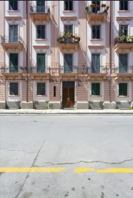 an empty street in front of a pink building at Dimora Alla Magione in Palermo