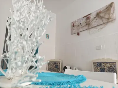 a dining room with a blue table and chairs at Holiday Home Green Paradise in Palermo