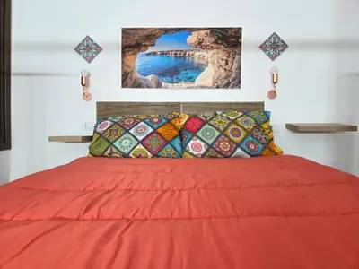 a bedroom with a red bed with a red blanket at La casetta di John in Palermo