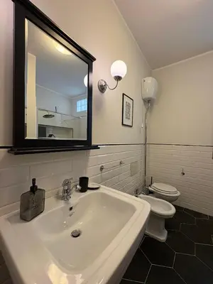 a bathroom with a white sink and a toilet at Nest - Family House in Santa Flavia