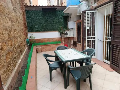 a patio with a table and chairs on a balcony at Franci Zisa House in Palermo