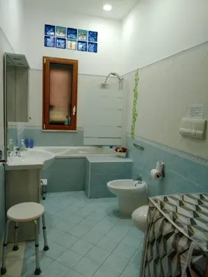 a bathroom with a tub and a toilet and a sink at Franci Zisa House in Palermo