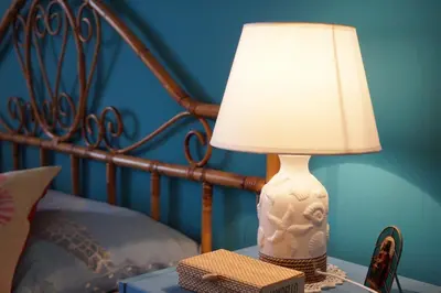 a lamp sitting on a table next to a bed at Orizzonte d'acqua Palermo in Palermo