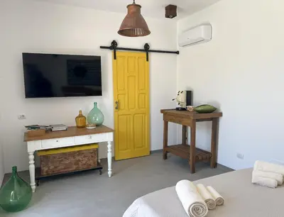 a bedroom with a yellow door and a desk at Rui2 Exclusive Accomodation in Terrasini