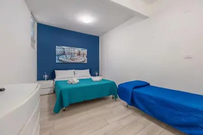 a blue bedroom with a bed and a tub at La loggia Apartment in Palermo