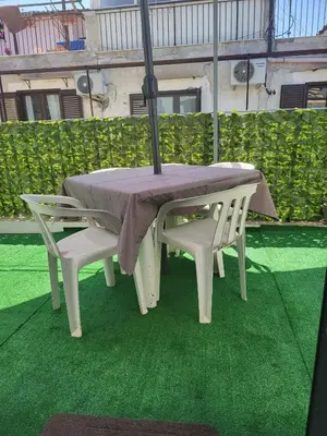 a table and two chairs with an umbrella at La loggia Apartment in Palermo