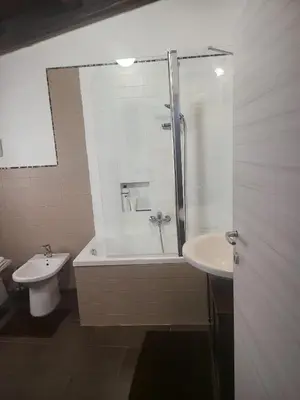 a bathroom with a shower and a toilet and a sink at La loggia Apartment in Palermo