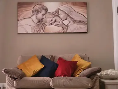 a painting of a couple holding a baby on a wall at La loggia Apartment in Palermo