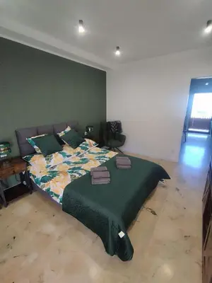 a bedroom with a large bed with a green blanket at Asia Sicilian Home in Carini