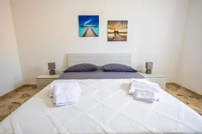 a bedroom with a large white bed with two pillows at Casa Cloe Mondello in Palermo